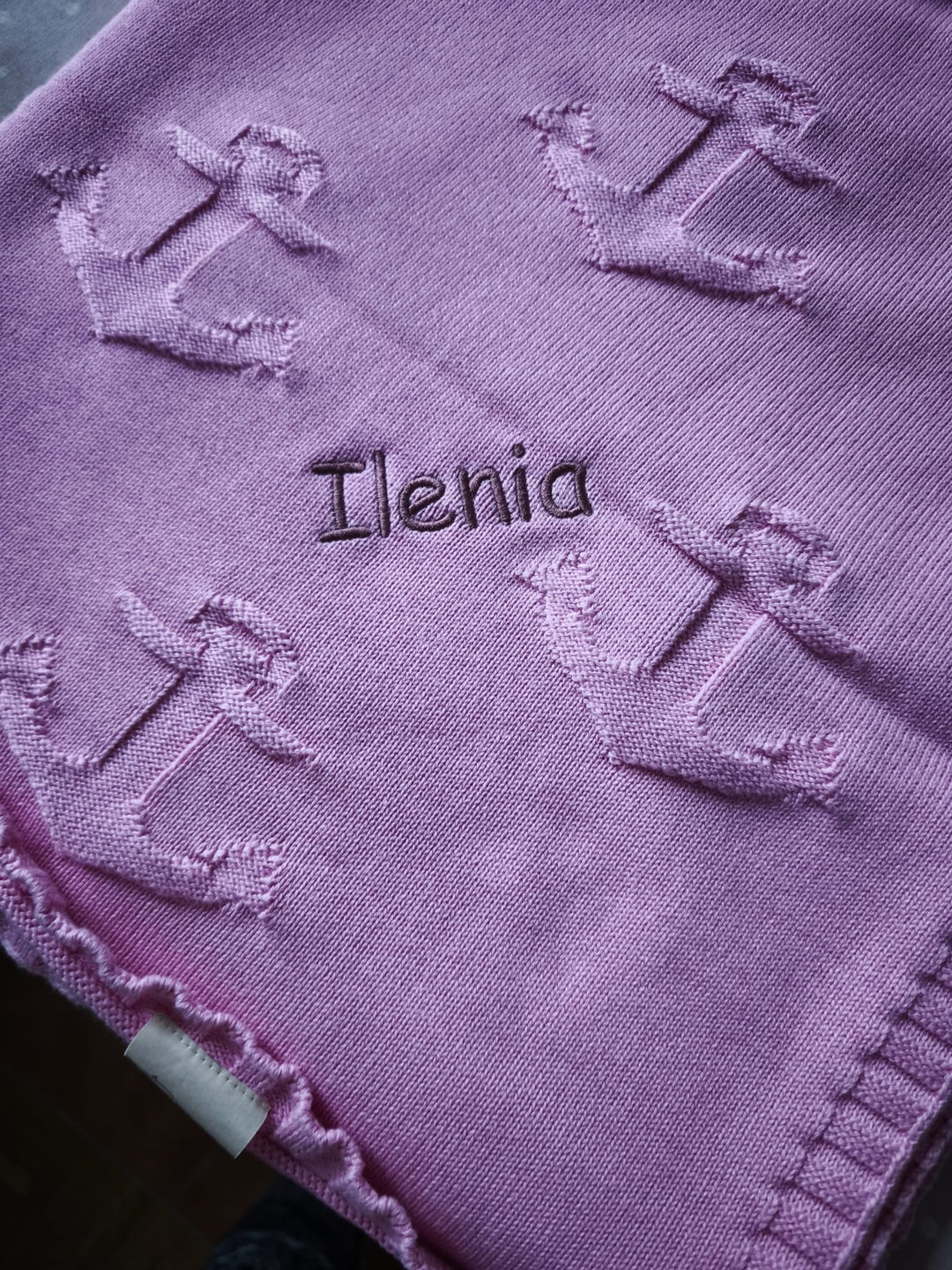Weiche rosa BIO Babydecke ANKERPLATZ mit Namen von babydecke.de, zeigt das liebevoll bestickte Design und kuschelige Oberfläche.